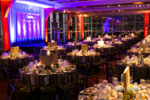Candlelit tables with floral arrangement, stage
