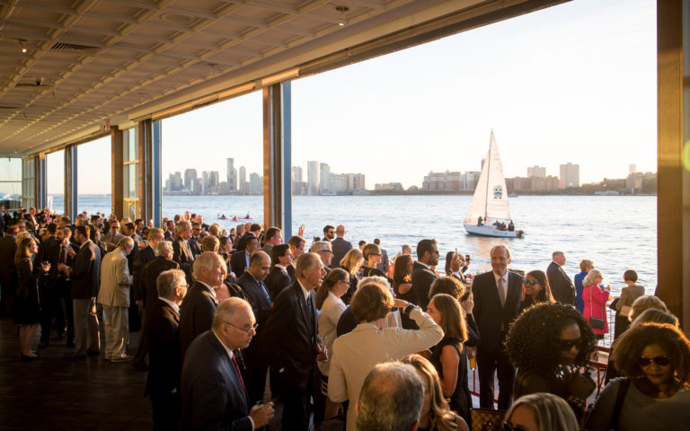 Pier Sixty Cocktail Hour with the garage open onto the Veranda, sail boat passes by