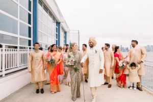 Bride and Groom, Bridal party behind at The Lighthouse Veranda