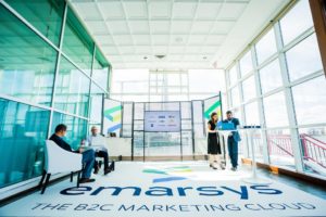 Booth by the windows, with attendees and booth attendants talking