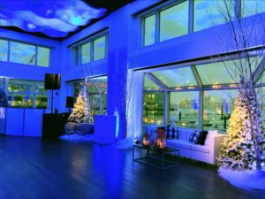 Current sat for a holiday party with fake snow, white christmas trees and candles