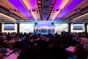 the audience watching a Choir on stage of a meeting at Pier Sixty