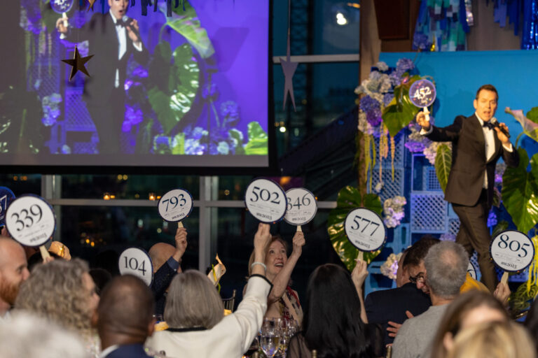 Guests bidding at the Live Auction at the Project Renewal Gala at Pier Sixty, Pier 60