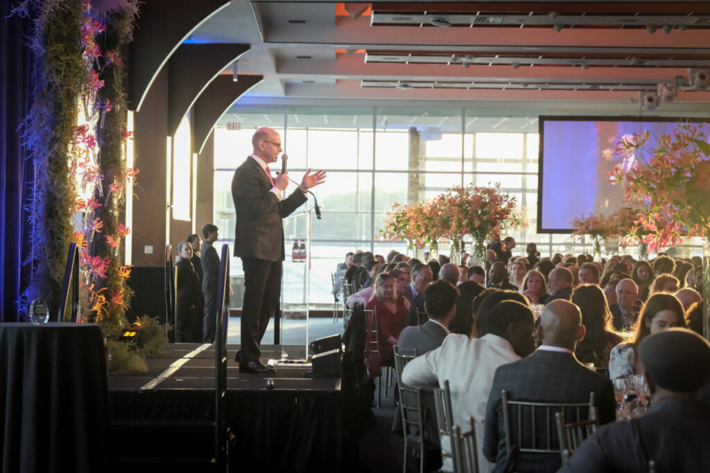 Speaker on stage speaking to guests at the Project Renewal Gala at Pier Sixty