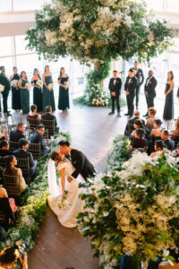 Bride and groom kissing down aisle at Current, Pier 59